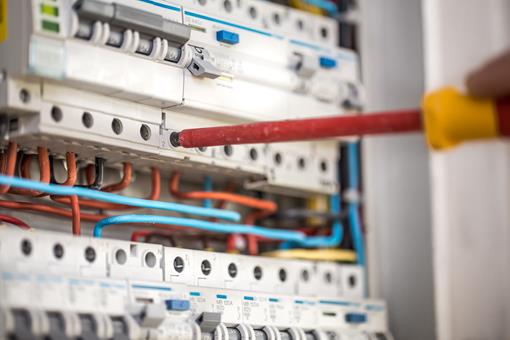 man-electrical-technician-working-switchboard-with-fuses-installation-connection-electrical-equipment-close-up.jpg